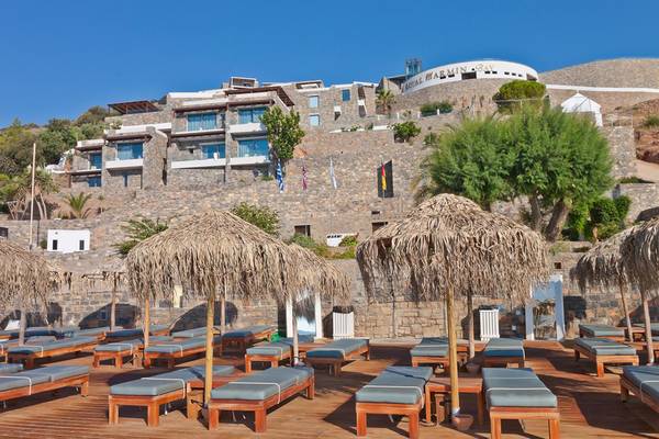 Terrasse des Royal Marmin Bay Boutique Hotels mit Sonnenliegen und Strohschirmen