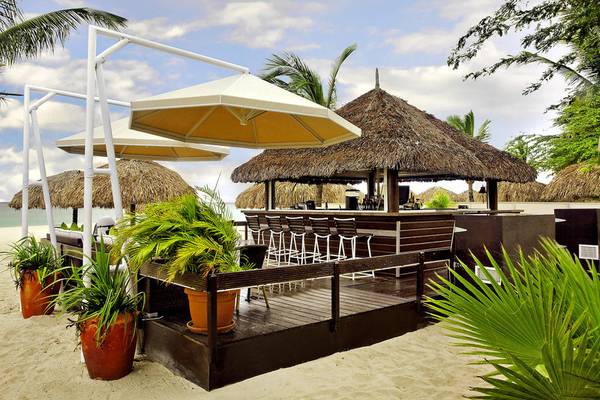 Bar am Strand des Amsterdam Manor Beach Resorts mit Sonnenschirmen und Pflanzen