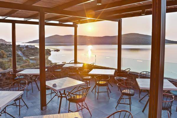 Terrasse des Royal Marmin Bay Boutique Hotels bei Sonnenuntergang mit Blick auf das Meer und die Berge.