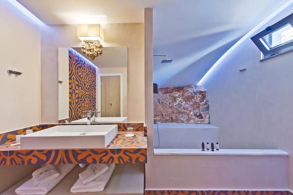 Badezimmer im Royal Marmin Bay Boutique Hotel mit einem Waschbecken und einer Badewanne.