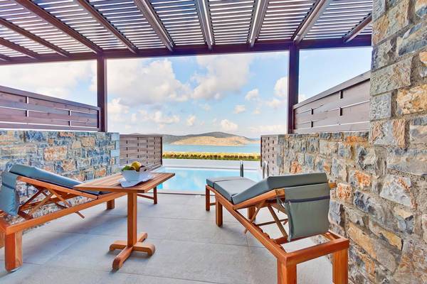 Terrasse des Royal Marmin Bay Boutique Hotels mit Blick auf den Pool und die Landschaft.