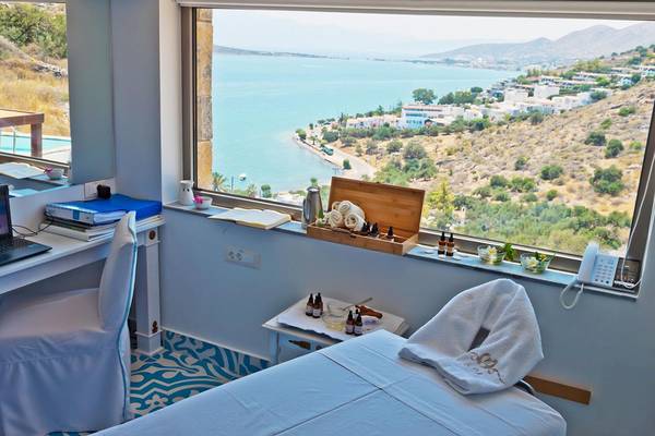 Massageraum im Royal Marmin Bay Boutique Hotel mit Meerblick und Schreibtisch.