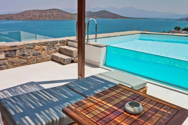Aussicht auf den Pool vom Royal Marmin Bay Boutique Hotel mit Meerblick und Lounge-Sesseln.