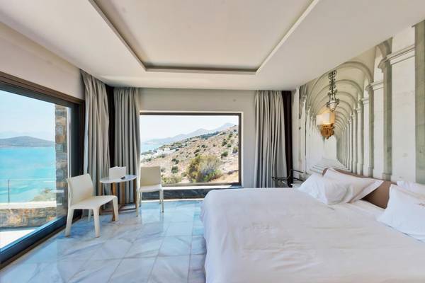 Ein elegantes Hotelzimmer mit Blick auf das Meer und einem großen Fenster.