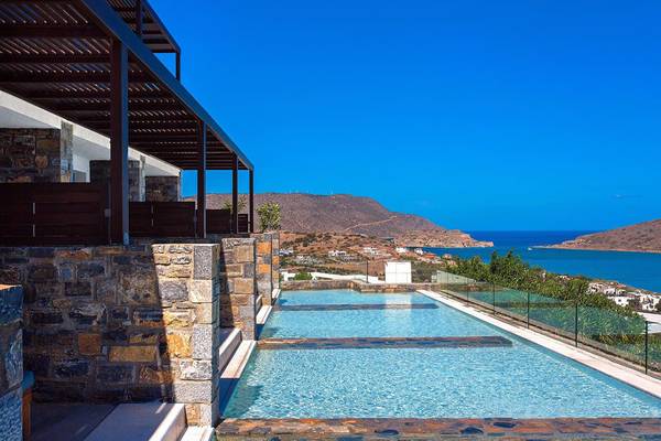 Außenpool des Royal Marmin Bay Boutique Hotels mit steinerner Einfassung und Meerblick.