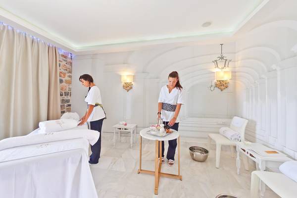 Behandlungsraum im Royal Marmin Bay Boutique Hotel mit zwei Angestellten und einem Tisch.
