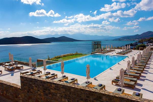 Aussicht auf das Royal Marmin Bay Boutique Hotel mit Swimmingpool und Blick auf das Meer und Berge.