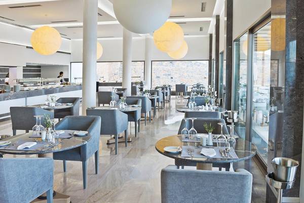Das moderne Restaurant des Royal Marmin Bay Boutique Hotels mit runden Tischen und grauen Stühlen.