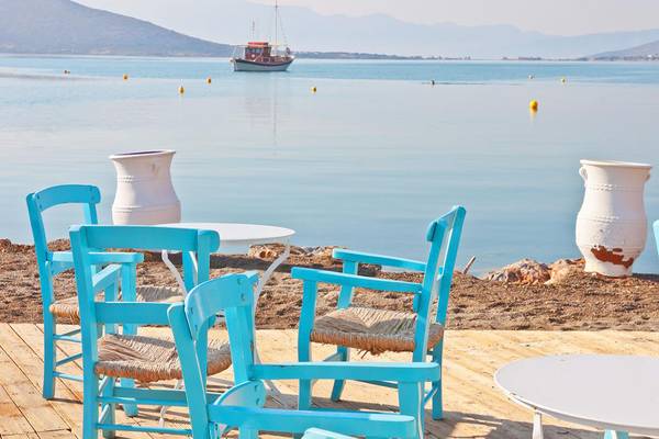 Terrasse des Royal Marmin Bay Boutique Hotel mit Tisch und Stühlen am Strand