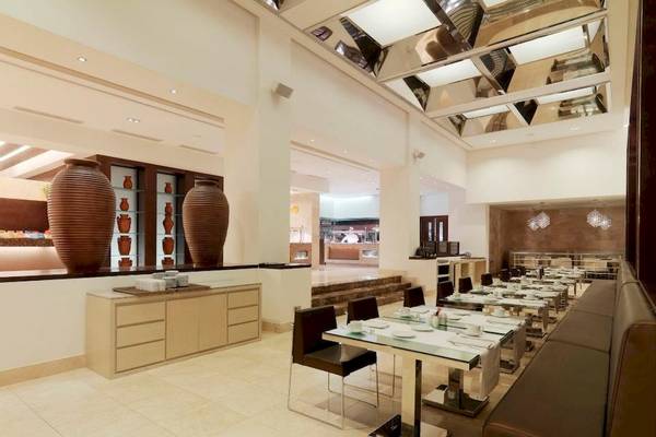 Innenansicht des Restaurants im Gran Melia Palacio de Isora Hotel mit runden Vasen und gefliestem Boden.