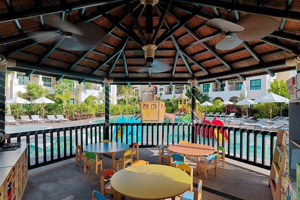 Kinder Spielbereich im Gran Melia Palacio de Isora Hotel mit bunten Tischen und Spielgeräten.