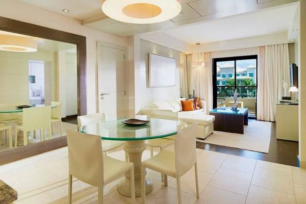 Innenbereich des Gran Melia Palacio de Isora mit Esstisch und Wohnzimmer.