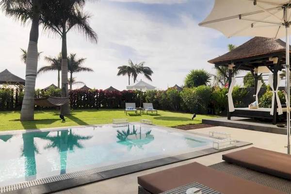 Pool im Freien mit einem Pavillon und Liegestühlen im Gran Melia Palacio de Isora Hotel.