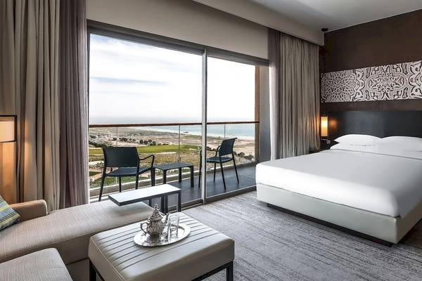 Hotelzimmer mit Meerblick im Hyatt Place Taghazout Bay, mit großem Bett, Balkon und Blick auf den Ozean.