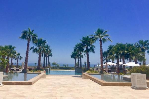 Poolbereich mit Palmen und Sonnenschirmen im Hyatt Place Taghazout Bay