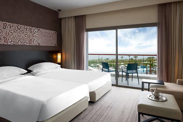 Doppelbett-Zimmer im Hyatt Place Taghazout Bay mit Blick auf den Pool und die Landschaft.