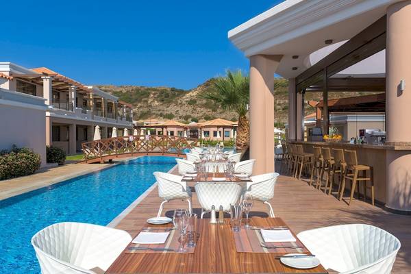 Außenrestaurant am Pool des La Marquise Luxury Resort Complex mit Tischen und Stühlen.