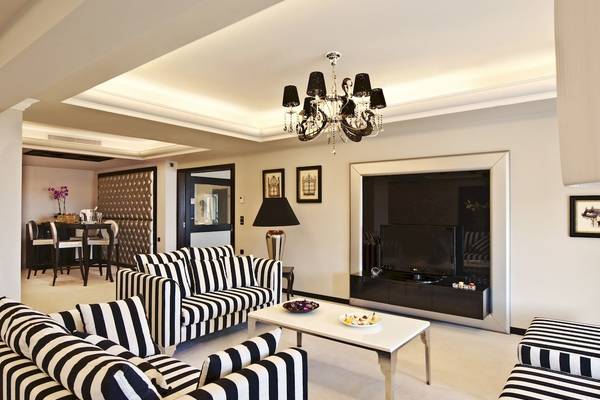 Wohnzimmer im La Marquise Luxury Resort Complex mit schwarzen und weißen Möbeln und einer Kristallkronleuchter.