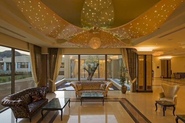 Foyer im La Marquise Luxury Resort Complex mit großen Fenstern, Sofas, Tischen und einer beleuchteten Decke.
