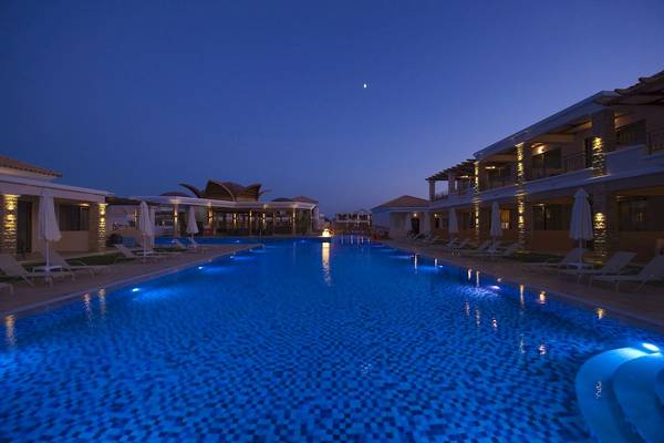 Pool im La Marquise Luxury Resort Complex bei Nacht mit blau beleuchtetem Wasser und umliegenden Liegen und Gebäuden