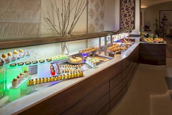 Buffet im La Marquise Luxury Resort Complex mit verschiedenen Desserts und Früchten.