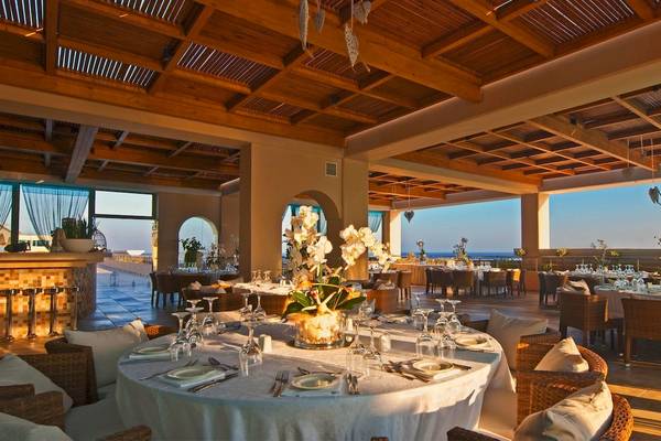Innenbereich des La Marquise Luxury Resort Complex mit Esstischen, Stühlen und einer Blumenvase.