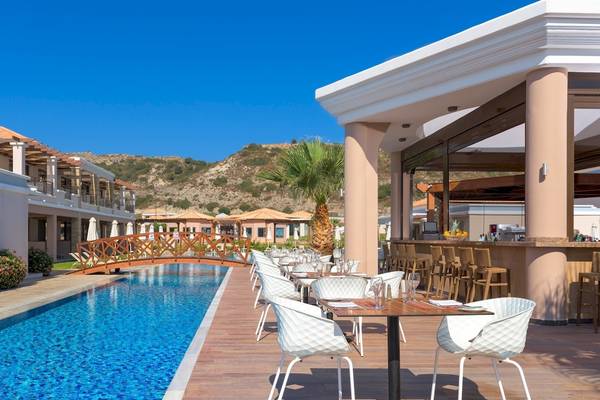 Außenbereich des La Marquise Luxury Resort Komplex mit Pool, Bar und Holzbrücke.