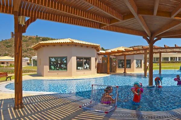 Außenpool des La Marquise Luxury Resort Complex mit spielenden Kindern und Sonnenschirmen.