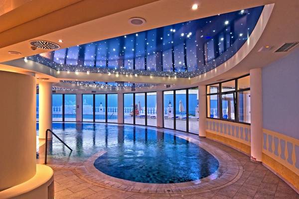 Innenpool des La Marquise Luxury Resort Complex mit Sternenhimmel-Decke und Blick auf Terrasse mit Liegen.