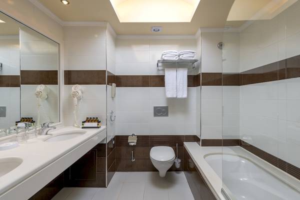 Badezimmer im La Marquise Luxury Resort Complex mit Badewanne, Dusche, Toilette, Handtüchern und Föhns.