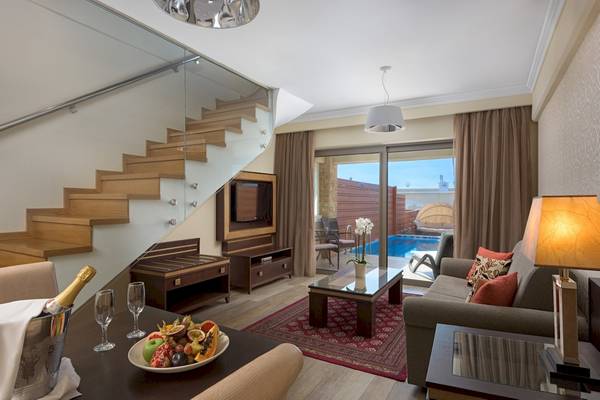 Wohnbereich des La Marquise Luxury Resort Complex mit Stehtisch, Sofa und Terrasse.