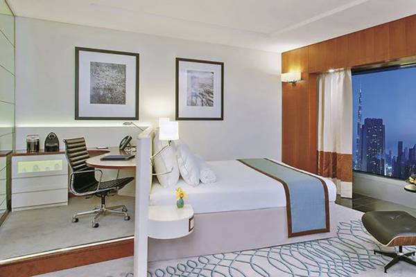 Hotelzimmer im Jumeirah Emirates Towers mit Schreibtisch, Bett, und Blick auf die Stadt
