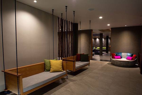 Loungebereich im Andaman Cannacia Resort mit hängenden Sofas und bunten Kissen.