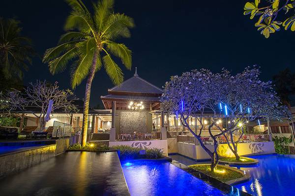 Nachtansicht des Andaman Cannacia Resorts mit beleuchtetem Pool und Bäumen