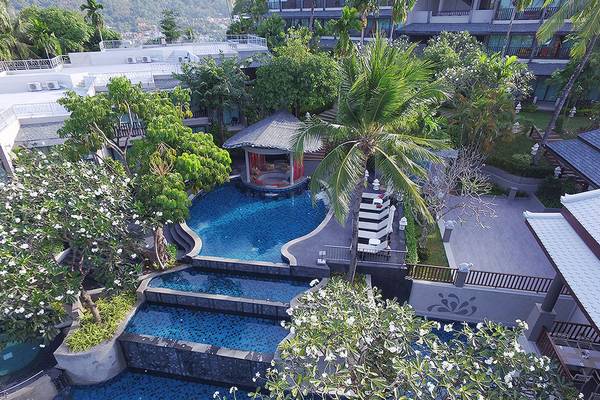 Luftaufnahme des Andaman Cannacia Resorts mit Swimmingpool und Sonnenliegen.