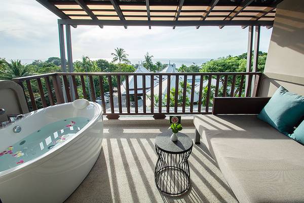 Balkon des Andaman Cannacia Resorts mit Badewanne und Sofa auf der rechten Seite.