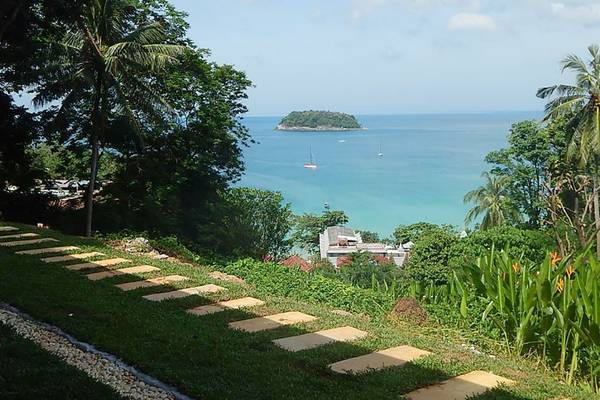 Aussicht auf das Meer vom Andaman Cannacia Resort mit Pfaden und Pflanzen.