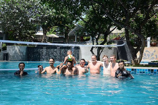 Gruppe von Männern und einem Kind im Schwimmbad des Andaman Cannacia Resorts
