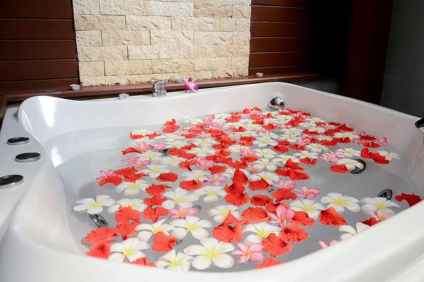 Whirlpool im Andaman Cannacia Resort mit roten und weißen Blumen