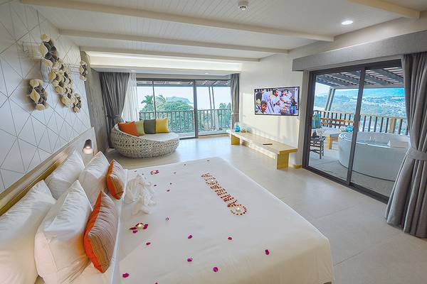 Eine Suite im Andaman Cannacia Resort mit einem großen Bett, Whirlpool und Aussicht.