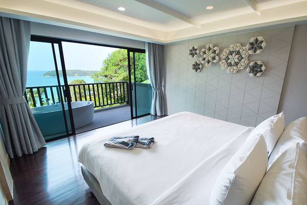 Schlafzimmer im Andaman Cannacia Resort mit Blick auf das Meer und einen Balkon