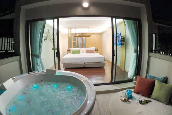 Suite im Andaman Cannacia Resort mit Whirlpool und Blick auf das Schlafzimmer.