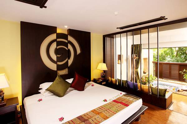 Ein modernes Hotelzimmer mit einem großen Bett, einem runden Wanddesign und einem Fenster mit Blick auf einen Whirlpool.