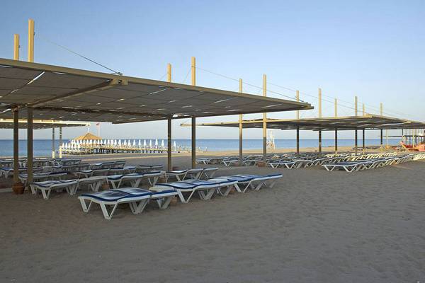 Strandbereich des Blue Waters Club Hotels mit Sonnenliegen und Sonnenschirmen