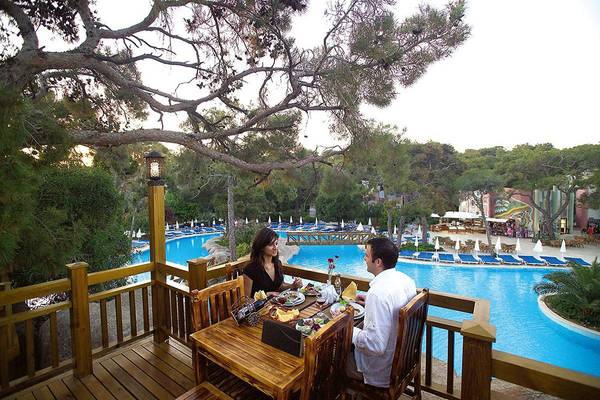 Paar isst auf einer Terrasse mit Poolblick im Blue Waters Club