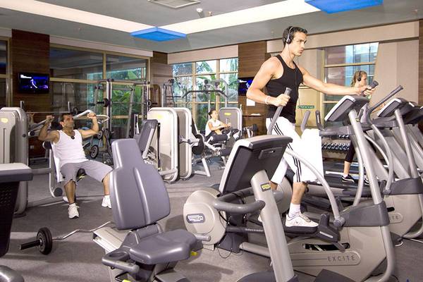 Fitnessstudio im Blue Waters Club mit Männern und Frauen, die an Geräten trainieren.