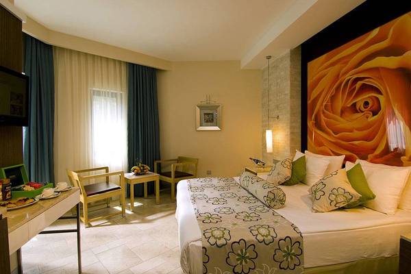 Ein modernes Hotelzimmer im Blue Waters Club mit einem großen Bett, Dekor und Möbeln.
