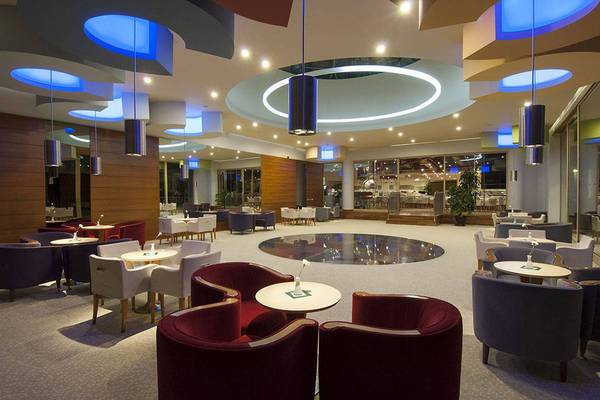 Lobby des Blue Waters Club Hotels mit modernen Möbeln und blauen Beleuchtungselementen.