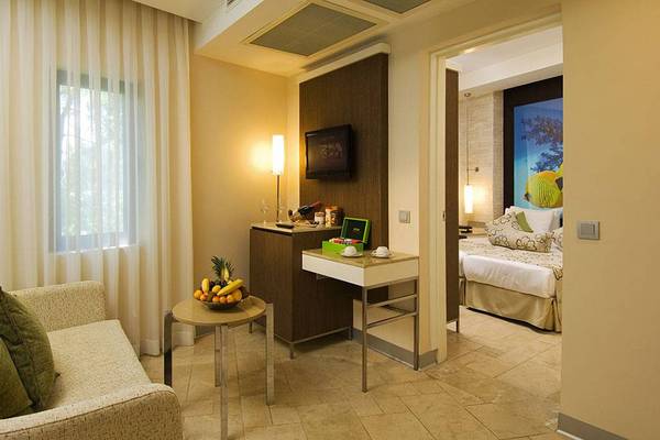 Hotelzimmer im Blue Waters Club mit Wohnzimmerbereich und angeschlossenem Schlafzimmer.