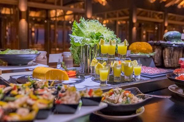 Buffet-Tisch im Innahura Maldives Resort mit verschiedenen Gerichten, Obst und Getränken.